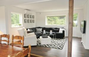 sala de estar con sofá negro y muebles blancos en Nice Home In rkelljunga With Kitchen, en Fasalt