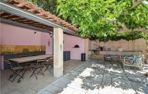 patio ze stołem i krzesłami pod pergolą w obiekcie Beautiful Home In Eyguieres With 4 Bedrooms, Wifi And Outdoor Swimming Pool w mieście Eyguières