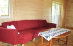 a living room with a red couch and a coffee table at Holiday Home Anolfsbyn Mellerud Ii in Annolfsbyn