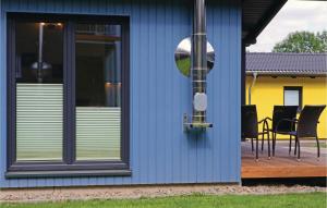 ein blaues Haus mit einer Terrasse mit Stühlen darauf in der Unterkunft Ferienhausdorf Thale in Thale