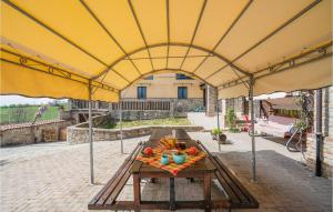 Una gran carpa amarilla con una mesa con fruta encima. en Nice Home In Marsaglia Cn With Jacuzzi, en Belvedere Langhe