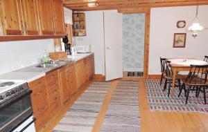 a kitchen with wooden cabinets and a table and a dining room at Holiday Home Vätinge Mellangård Tranås in Gripenberg