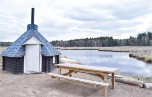 a small hut with a bench next to a lake at 5 Bedroom Lovely Home In Ruda in Ruda