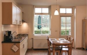 a kitchen with a table and chairs and two windows at Dorsvloer in De Moer