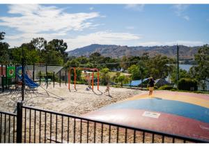 zwei Kinder spielen auf einem Spielplatz in einem Park in der Unterkunft Discovery Parks - Lake Hume, New South Wales in Lake Hume