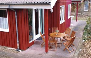 eine Terrasse mit einem Tisch und Stühlen neben einem roten Gebäude in der Unterkunft Beautiful Home In Extertal With 3 Bedrooms, Sauna And Wifi in Rott