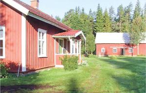 a red house and a red barn in a yard at Awesome Home In Grimss With Sauna in Hestra
