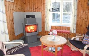 a living room with a wood stove and a table at Awesome Home In Grimss With Sauna in Hestra