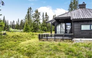 een hut in een veld met bomen op de achtergrond bij Cozy Home In Sjusjen With Kitchen in Sjusjøen