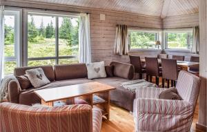 een woonkamer met een bank en een tafel bij Cozy Home In Sjusjen With Kitchen in Sjusjøen