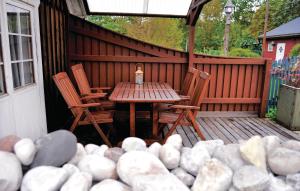 una mesa de madera y sillas en un patio con rocas en Gorgeous Home In Lrbro With Kitchen en Lärbro