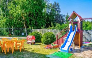 un pequeño patio trasero con un parque infantil con un tobogán en Awesome Home In Dzwirzyno With House A Panoramic View en Dźwirzyno