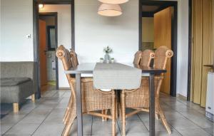 ein Esszimmer mit einem Tisch und Korbstühlen in der Unterkunft Awesome Home In Bischofsheim With 3 Bedrooms in Bischofsheim an der Rhön