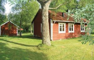 une maison rouge avec un arbre devant elle dans l'établissement Beautiful Home In Bottnaryd With Kitchen, à Bottnaryd