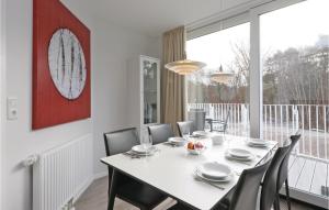 uma sala de jantar com uma mesa branca e cadeiras em Dnenvilla em Travemünde