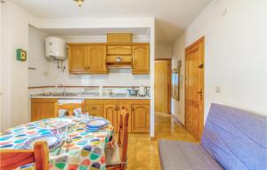eine Küche mit Holzschränken und einem Tisch im Zimmer in der Unterkunft Nice Apartment In Santa Pola With Swimming Pool in Santa Pola
