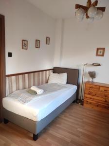 a bedroom with a bed and a lamp and a dresser at Füvesi Vendégház in Balatonfüred