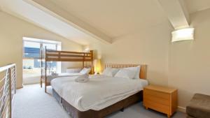 a bedroom with a bed with a teddy bear on it at Chalet Hotham 20 in Mount Hotham