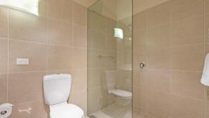 a bathroom with a toilet and a glass shower at Chalet Hotham 20 in Mount Hotham