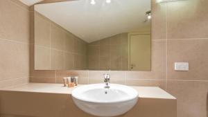 a bathroom with a white sink and a mirror at Chalet Hotham 20 in Mount Hotham