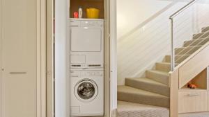 a laundry room with a washer and dryer and stairs at Chalet Hotham 20 in Mount Hotham