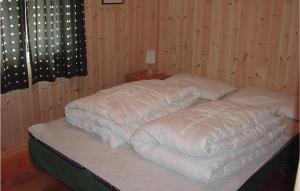 een bed met twee kussens erop bij Nice Home In Kvinlog With 5 Bedrooms in Stakkeland