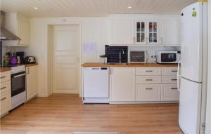 una cucina con elettrodomestici bianchi e pavimenti in legno di 3 Bedroom Cozy Home In Aurskog a Urskog
