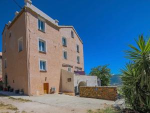 a large brick building with a palm tree in front of it at Casa di Emma in Santo-Pietro-di-Tenda