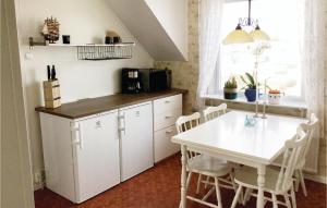 een keuken met een witte tafel en een tafel en stoelen bij Nice Apartment In Hyppeln With Wifi in Hyppeln