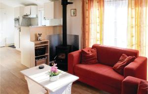 a living room with a red couch and a fireplace at 2 Bedroom Nice Home In Tzummarum in Tzummarum