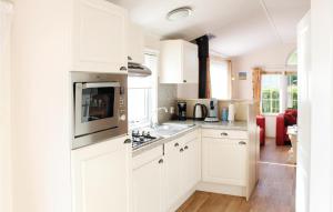 a kitchen with white cabinets and a stove top oven at 2 Bedroom Nice Home In Tzummarum in Tzummarum