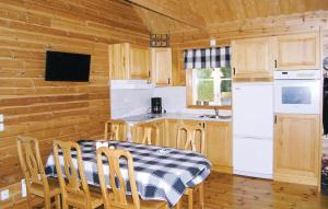 kuchnia ze stołem i białą lodówką w obiekcie Gorgeous Home In senhga With Kitchenette w mieście Ekhult