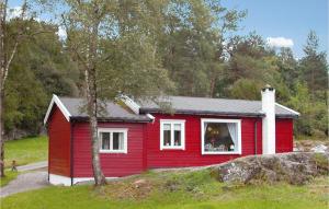 uma casa vermelha com uma janela branca e uma árvore em Nice Home In Etne With House Sea View em Børkjenes