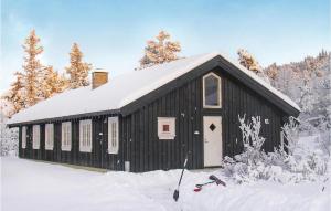 Awesome Home In Gl With House A Mountain View في Gålå: مبنى أسود عليه ثلج