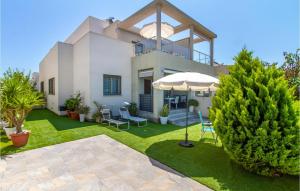 duży dom z parasolem i trawnikiem w obiekcie 3 Bedroom Stunning Home In Torrevieja w mieście Torrevieja