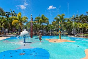 people are playing in a swimming pool at Discovery Parks - Mackay in Mackay