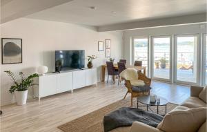 a living room with a television and a table with chairs at Amazing Apartment In Svanesund With Kitchen in Svanesund