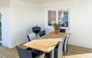 a wooden table and chairs in a room with a window at Amazing Apartment In Svanesund With Kitchen in Svanesund