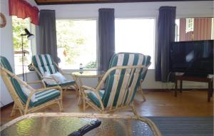 ein Wohnzimmer mit Stühlen, einem Tisch und einem TV in der Unterkunft Awesome Home In Arkelstorp With 2 Bedrooms in Immeln