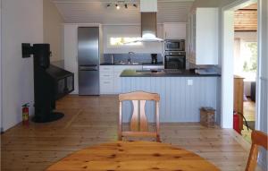 a kitchen with a wooden floor and a chair in it at Awesome Home In Arkelstorp With 2 Bedrooms in Immeln