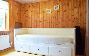 a white bed in a room with wooden walls at Stunning Home In Vstervik With Kitchen in Västervik