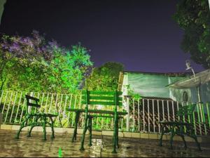 a table and two chairs next to a fence at Pousada 4 cantos in Corumbá