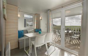 een kamer met een tafel en stoelen en een balkon bij Huisje Blauwe Hoek in Westerland