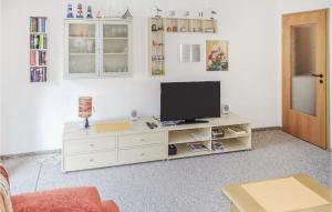 ビューズムにあるAwesome Apartment In Bsum Ot Westerdeichs, With 1 Bedroomsの白いキャビネット上のテレビ付きのリビングルーム