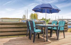 una mesa y sillas con una sombrilla en la cubierta en Bungalowpark Wijdland - Aak en Bunschoten