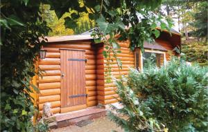 a wooden cabin with a door in a garden at Awesome Home In Crinitzberg With Kitchen in Bärenwalde