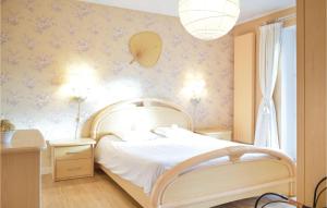 - une chambre avec un lit blanc et des fleurs sur le mur dans l'établissement Villa Pascale, à Robertville
