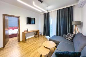 salon z kanapą i stołem w obiekcie Deluxe Central Rooms w mieście Karłowo