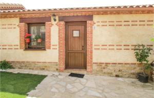 een stenen huis met een houten deur en een raam bij Nice Home In Aldeanue, De La Sierra With Ethernet Internet in Aldeanueva de la Sierra