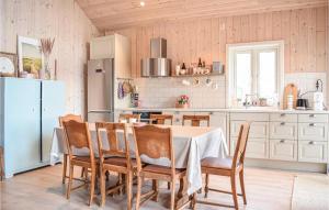 cocina con mesa, sillas y nevera en Cozy Home In Fjelberg With Kitchen en Vik
